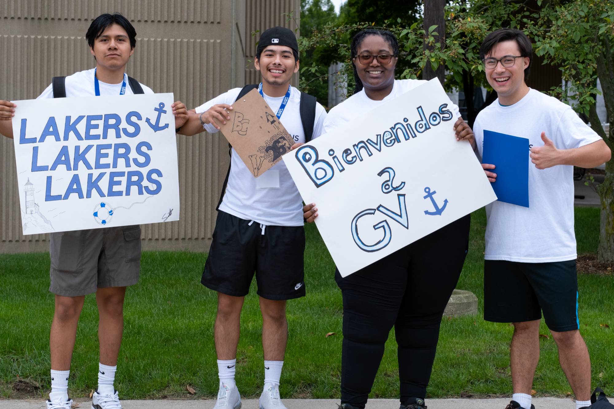 Students holding signs welcoming new students to campus